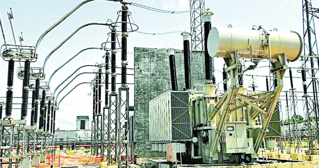 A high-voltage electricity substation with transformers and transmission towers